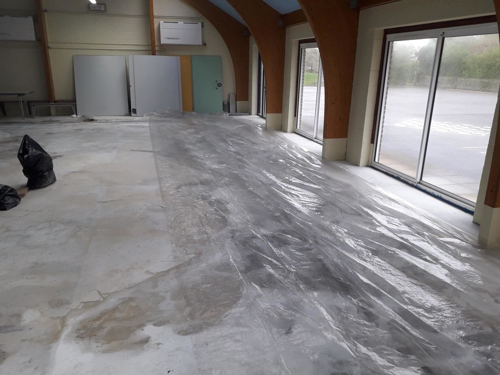Latex screeding and floor levelling preparation in a large hall — professional floor fitter in Essex